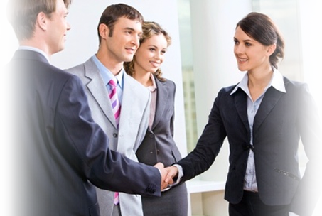 Four professionals standing shaking hands